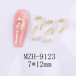 Detailed view of 7x12mm golden curved nail art charms with embedded white pearls