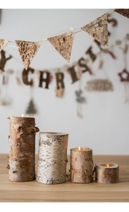 Detail of natural birch wood candle holders in varying heights for rustic table decor