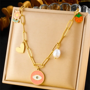 Gold titanium steel necklace with enamel heart flower and eye pendants on display