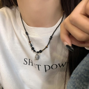 Close-up of beaded necklace with tiger head pendant and brown tiger eye stones