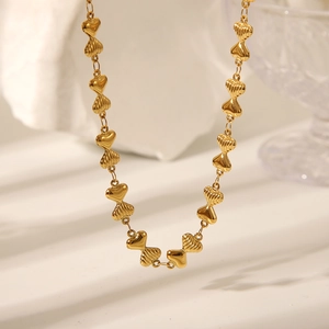 Dettaglio collana placcata oro 18K con maglie a cuore e texture a strisce verticali
