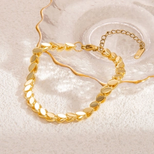 Macro detail of leaf-shaped titanium steel links on a gold bracelet with S.Steel hallmark