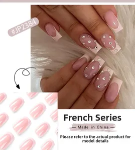 Macro detail of pink French press-on nails with white tips and sparkling rhinestone accents