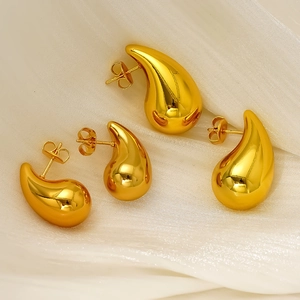 Boucles d'oreilles gouttes dorées polies en deux tailles sur tissu en soie blanc