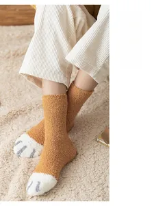Close-up of cozy ginger coral fleece socks with white cat paw embroidery detail