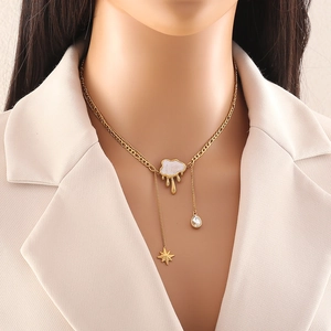 Collana con ciondolo a nuvola, catena dorata, nappa a stella e cristallo su una modella