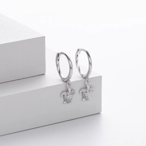 Elegant S925 sterling silver hoop earrings with detailed sea turtle pendants on white stage