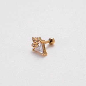 Detail of gold barbell stud earring featuring a triangular gem and leaf-shaped stones