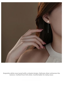 Close-up of elegant 925 sterling silver white rose tassel earrings on female model