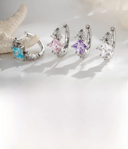 Detail view of square zircon earrings in blue, pink, purple, and clear colors