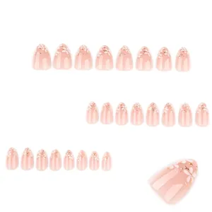 Faux ongles amande courts avec fleurs blanches et dorures effet 3D sur base rose nude