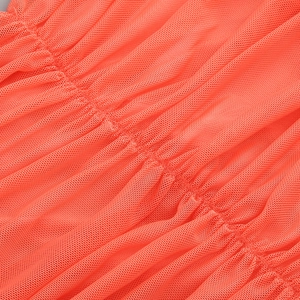 Detailed macro view of coral orange ruched mesh fabric texture for a mesh bodycon dress