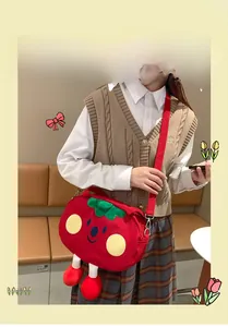 Close-up of cute 3D strawberry plush bag with tiny legs and adjustable red strap
