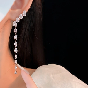 Detailed close-up of long silver tassel earrings with gradient pear-cut zircon stones