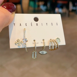 Detailed shot of 5-piece gold earring set with zircon charms and silver posts