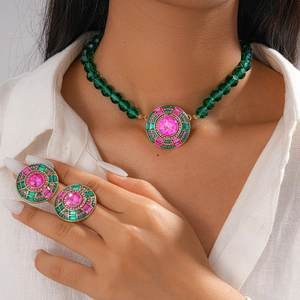 Détail de l'ensemble de bijoux ethniques avec collier de perles vertes et bagues serties