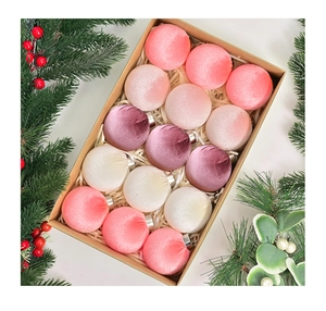 Close-up of 15 velvet Christmas balls in pink and burgundy in a kraft gift box