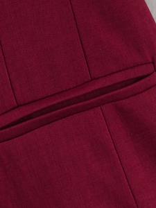 Macro shot of fine twill texture and precision stitching on burgundy plaid blazer pocket