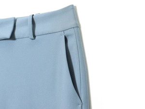 Dettaglio dei pantaloni a zampa azzurro chiaro con focus su vita e tasca laterale