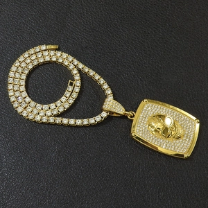 Vue détaillée d'une chaîne tennis hip hop avec pendentif tête de mort doré et strass