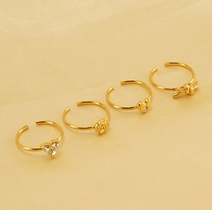 Close-up of four 18K gold plated adjustable rings with rose, heart and knot designs
