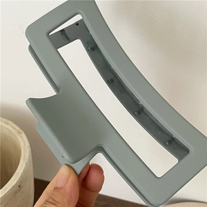 Macro detail of large rectangular matte hair claw clip in Morandi green finish