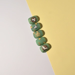 Detailed view of dark green nail art stickers featuring golden cranes and clouds