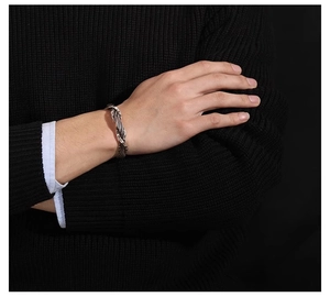 Detail of handmade hammered Thai silver weave open cuff bracelet on male model wrist