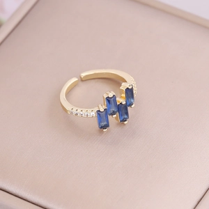 Detailed macro view of 18K gold ring featuring three rectangular blue zircon gemstones