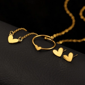 Elegant gold heart jewelry set including necklace, adjustable ring, and stud earrings