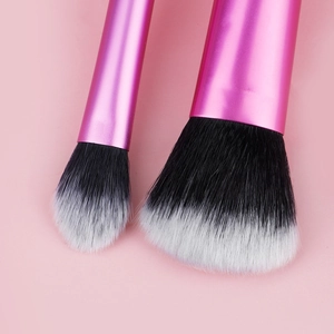 Macro detail of bicolored makeup brush bristles with a metallic fuchsia handle