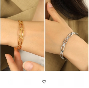 Detailed close-up of gold and silver chain link bracelets with bold industrial design
