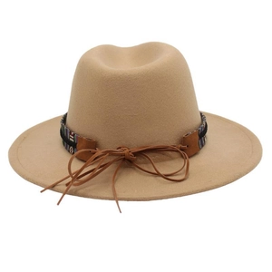 Detail of bohemian ethnic woven band and leather knot on khaki wool felt jazz hat