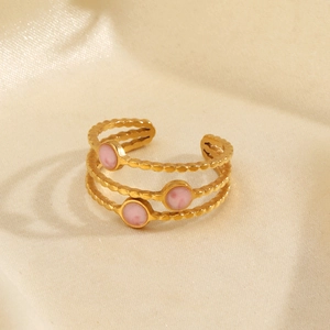 Gold-plated 3-layer wave ring with pink round stones on elegant satin background
