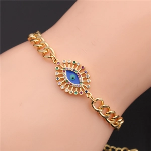 Detailed close-up of a golden Cuban chain bracelet featuring a colorful zircon Evil Eye charm