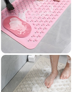 Close-up of pink and beige bathroom mats with non-slip suction cups and massage nubs