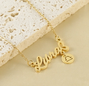 Detail of 18k gold Libra constellation pendant necklace on minimalist stone background