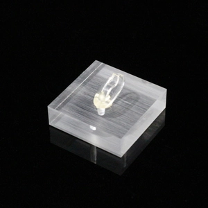 Clear acrylic ring display stand with square base on reflective black surface