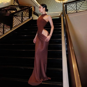 Detail view of brown sleeveless maxi dress with sexy waist cutout on luxury hotel stairs