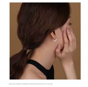 Close-up of elegant gold beaded pearl hoop earrings worn by a model in soft lighting