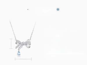 Macro detail of S925 silver bow necklace with pear shaped blue topaz pendant