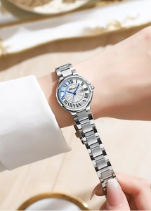 Detail of silver quartz watch with white Roman dial, date window, and steel strap