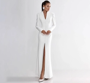 Detail of elegant white V-neck dress featuring front row buttons and a high slit