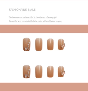 Detail of square nude nails with 3D butterfly charms and micro pearls on pink base