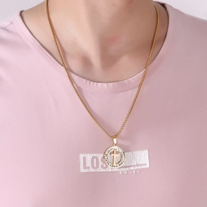 Close-up of gold cross pendant necklace with sparkling zircons worn on a female model