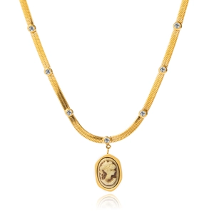 Close-up of gold snake chain necklace with sparkling crystals and embossed portrait pendant