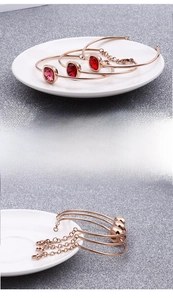 Dettaglio del bracciale in oro rosa con zircone rosso quadrato e finitura in metallo