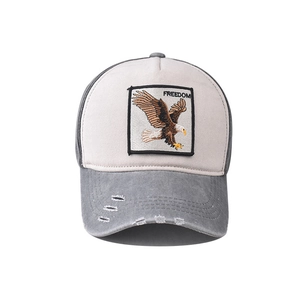 Detail of eagle embroidery freedom patch and distressed holes on washed baseball cap