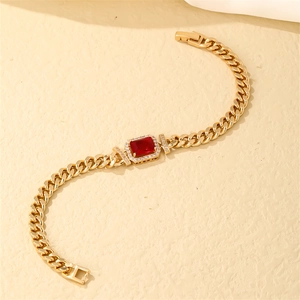 Close-up of golden Cuban link bracelet with rectangle red zircon and pavé crystals
