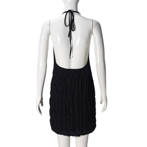 Detail of backless black halter dress with pleated texture and adjustable neck ties